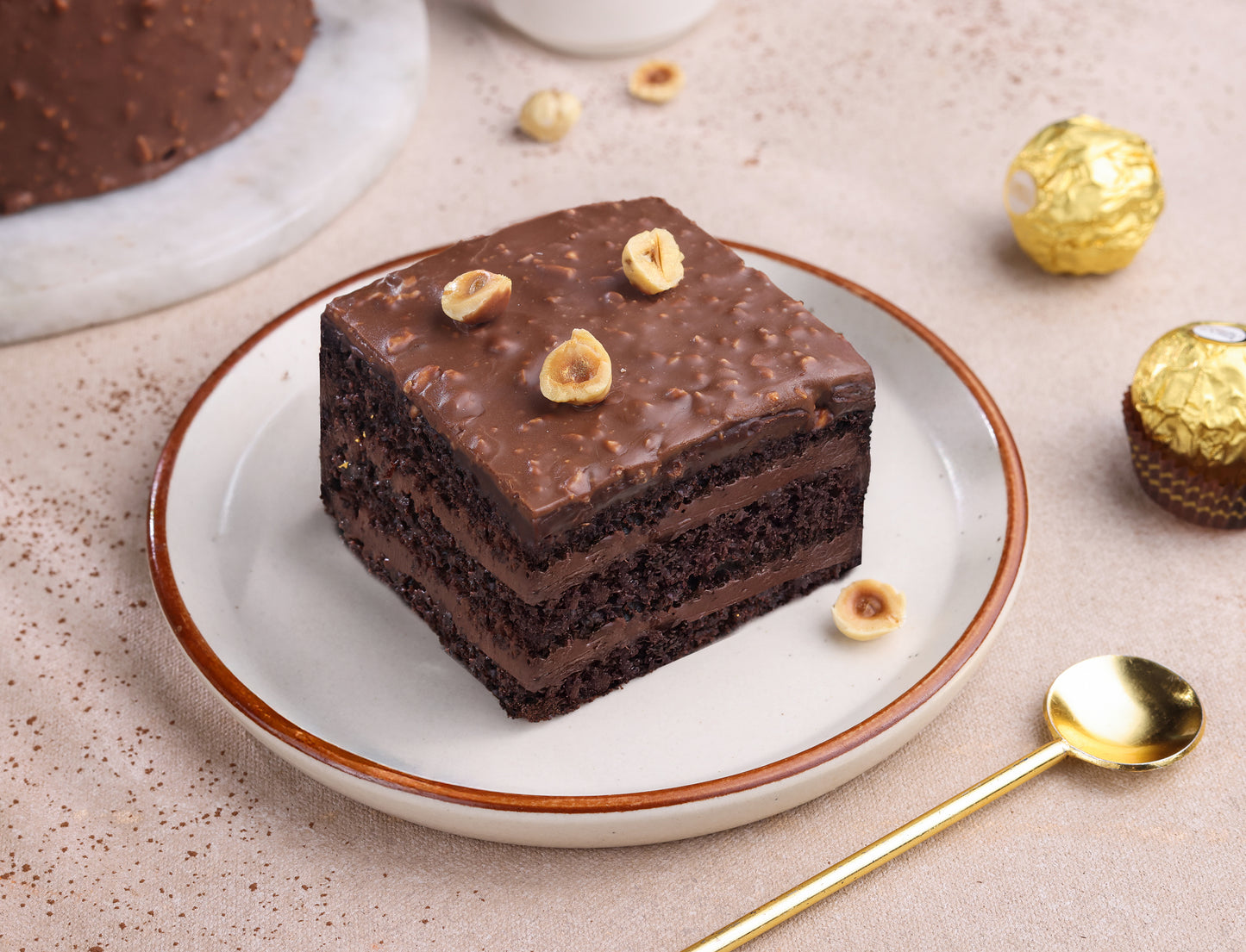 Square dark chocolate hazelnut pastry with crunchy topping on a white plate.