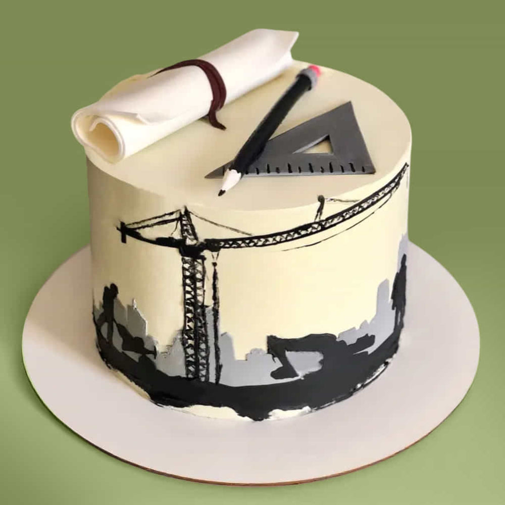 Beige round cake with a construction theme, featuring a crane silhouette around the sides and topped with a rolled fondant scroll, pencil, and triangular ruler.