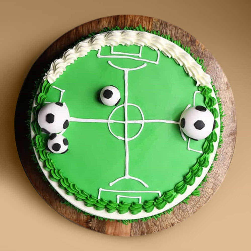 Cake decorated like a soccer field with goalkeepers on a wooden board