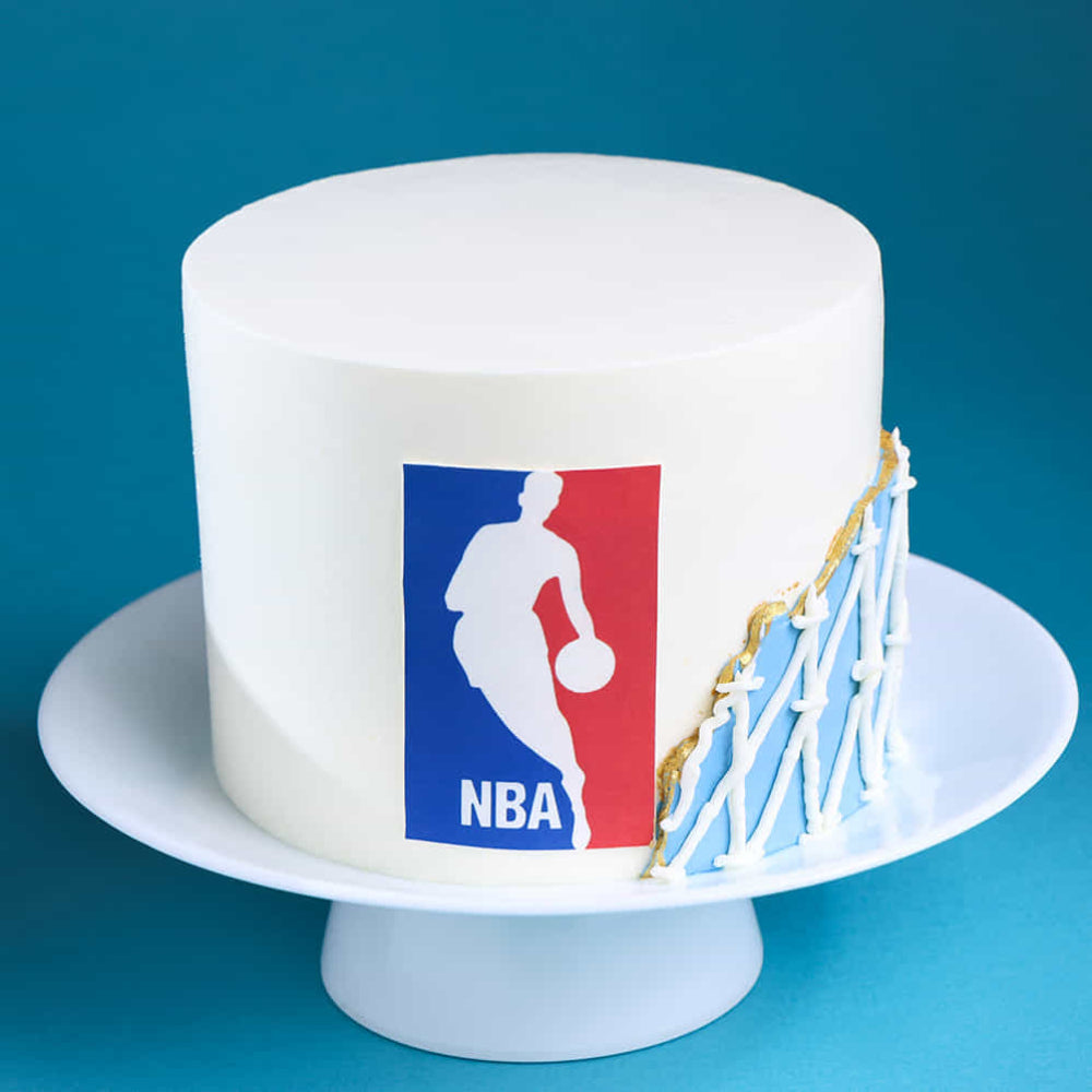 White cake with NBA logo and basketball hoop on a blue background