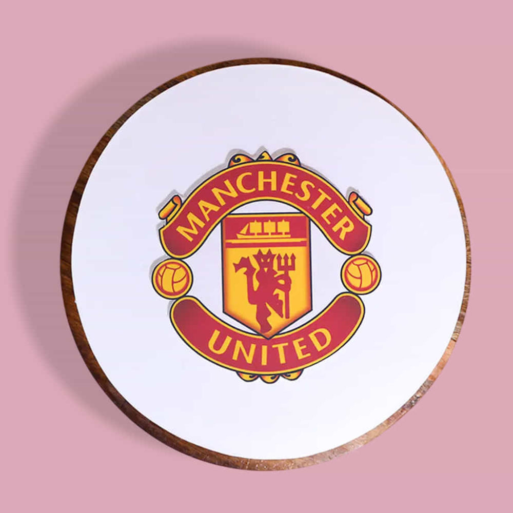 Manchester United logo on a circular coaster with a pink background