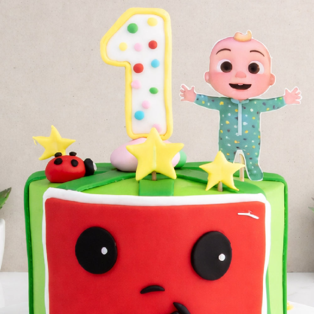 Cute first birthday designer cake with number one topper, baby cartoon figure, star decorations, and watermelon theme design, perfect for kids celebration.