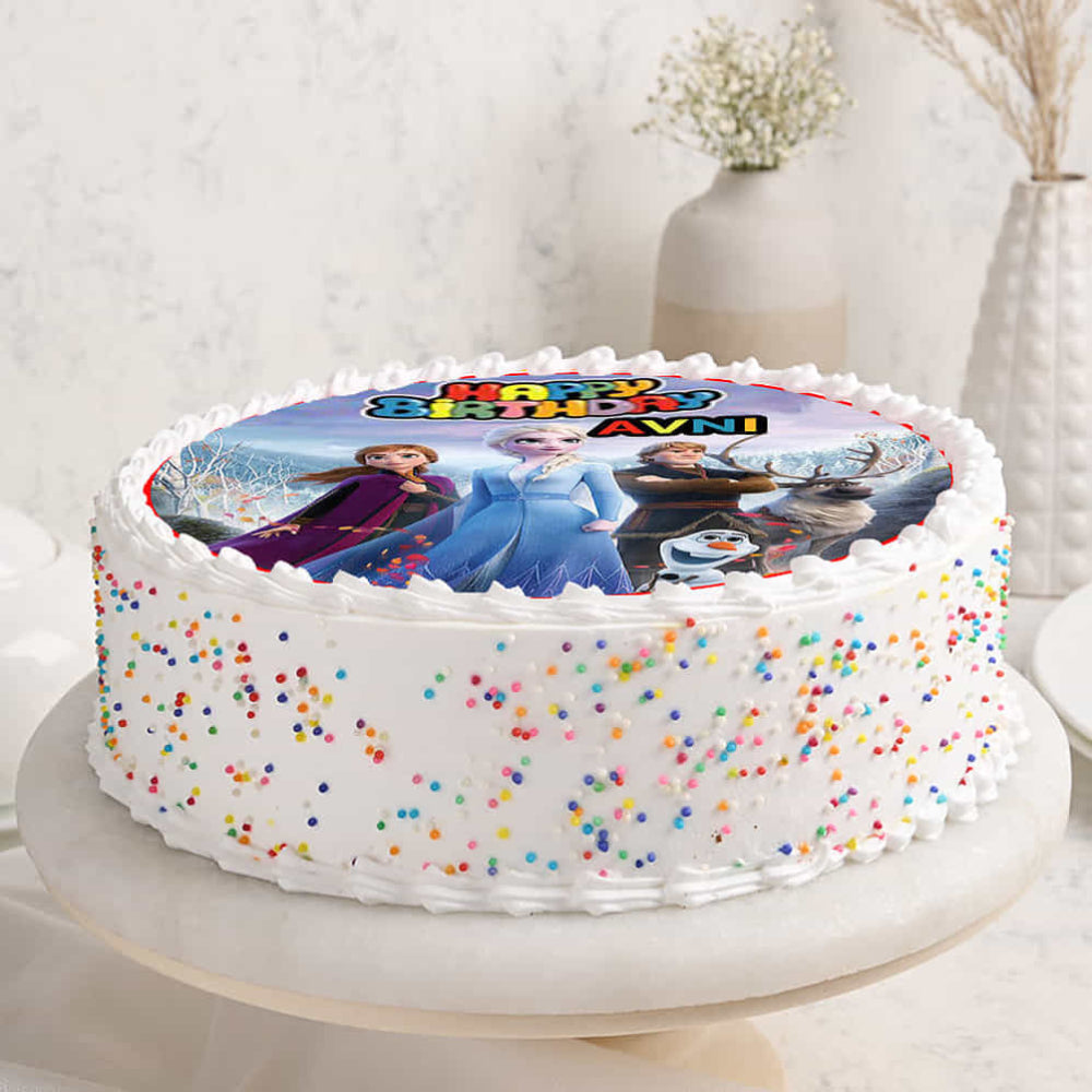 Birthday cake with colorful sprinkles and a Frozen-themed photo on a white surface.