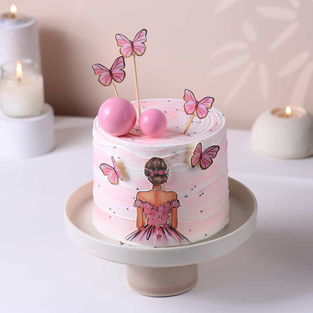 Small pink cake with butterfly decorations on a white surface