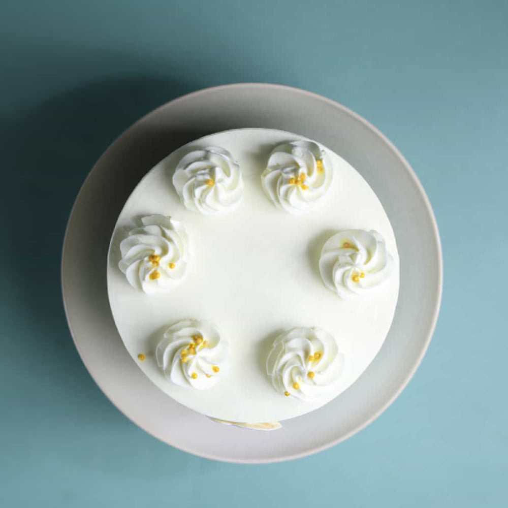 Top view of a simple white cream cake with swirl frosting design, perfect for birthdays and celebrations in Delhi.