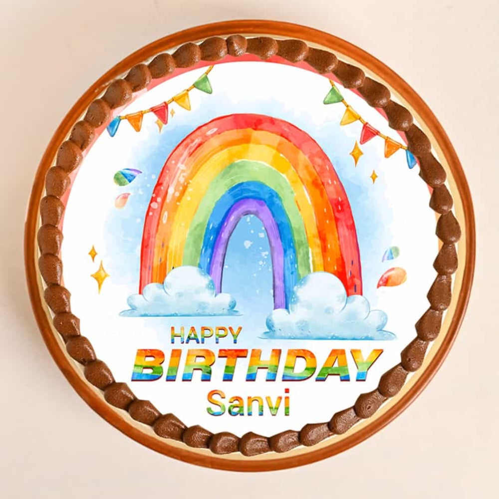 Round cake with rainbow design and 'Happy Birthday Sani' text on a light background