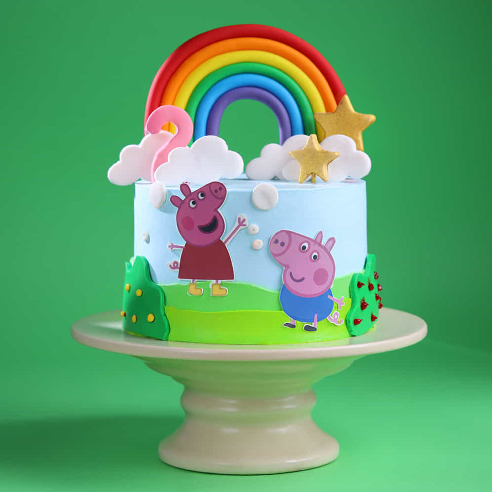 Peppa Pig rainbow theme designer cake with colorful decorations and cartoon characters, perfect for kids birthday celebrations in Delhi.