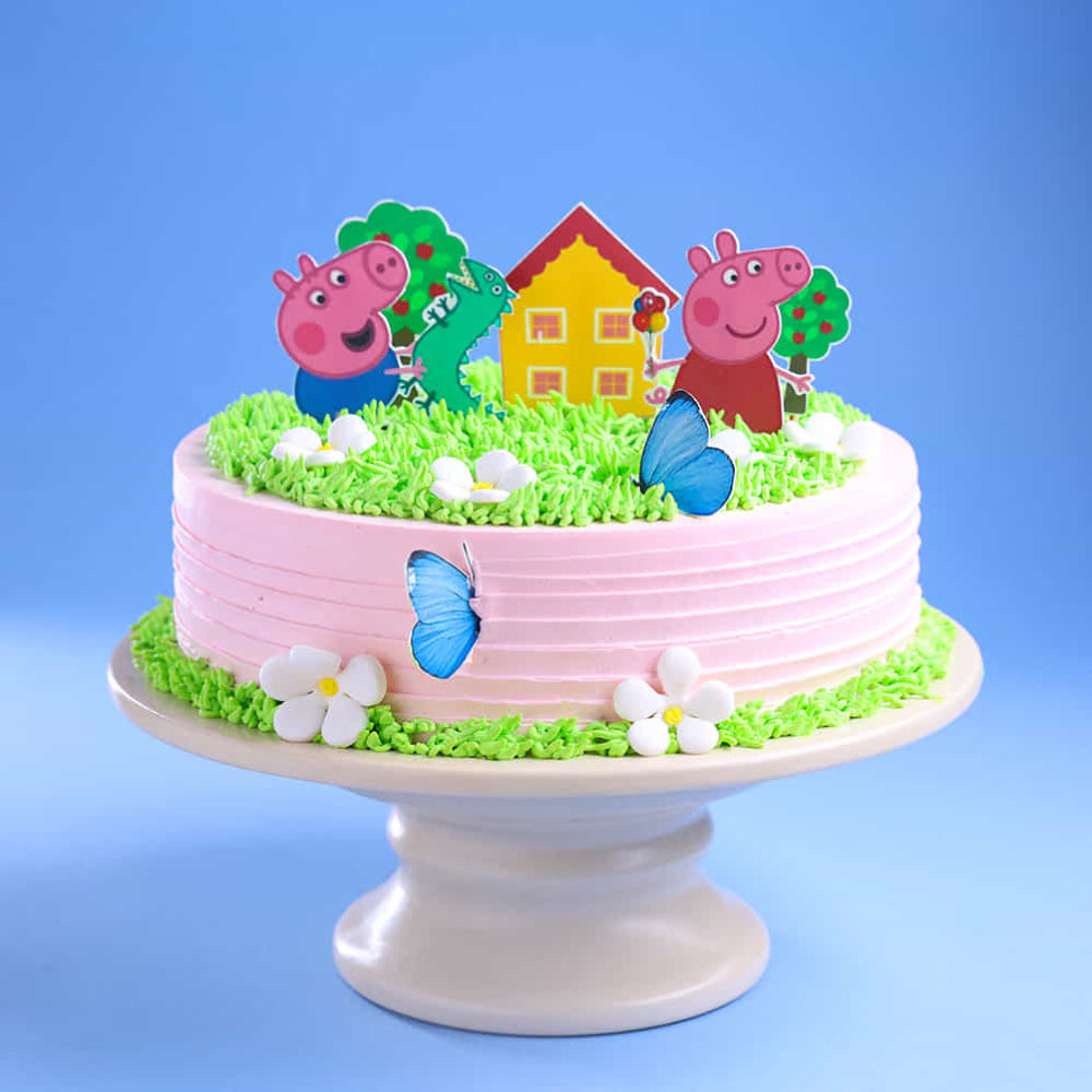 Peppa Pig theme designer cake with garden scene, green grass icing, and cartoon toppers, perfect for kids birthday celebrations in Delhi.