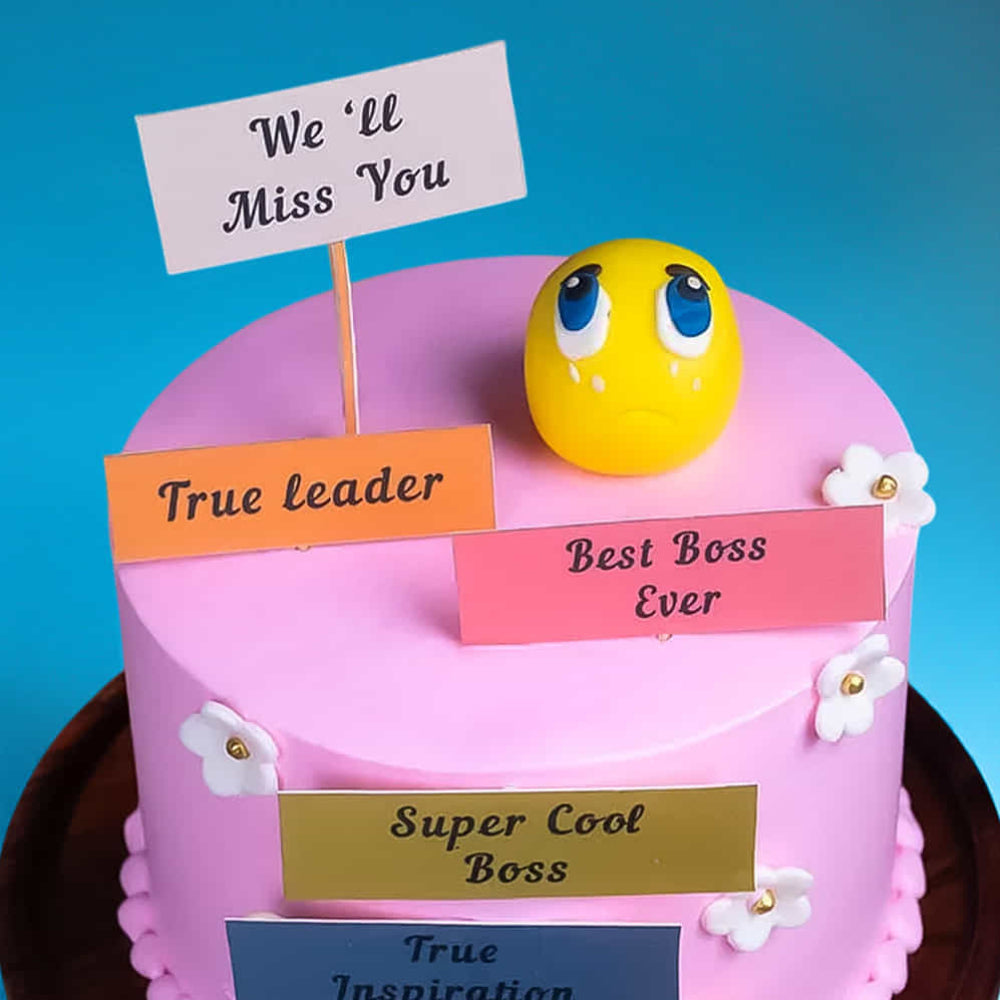 Pink farewell cake for a boss with a sad emoji and "We'll Miss You" messages.