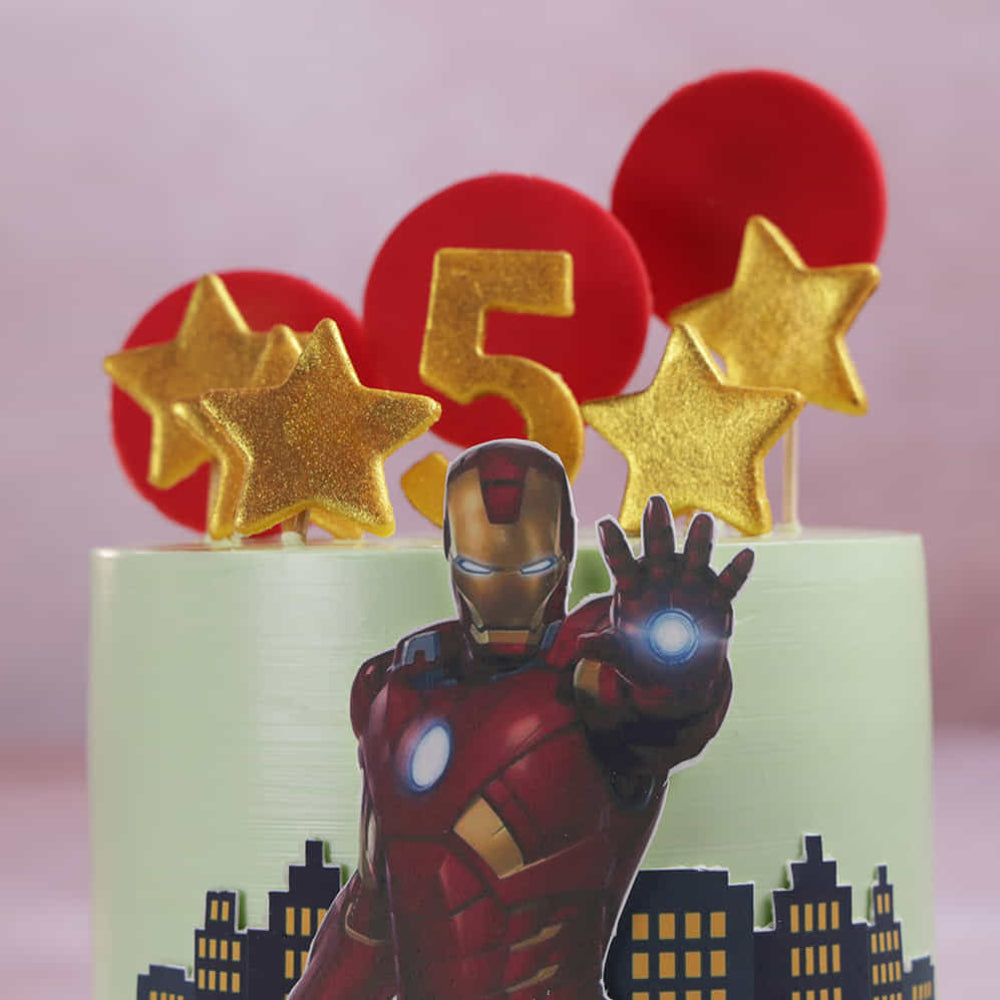 Cake with Iron Man character and number 5 candles on a pink background