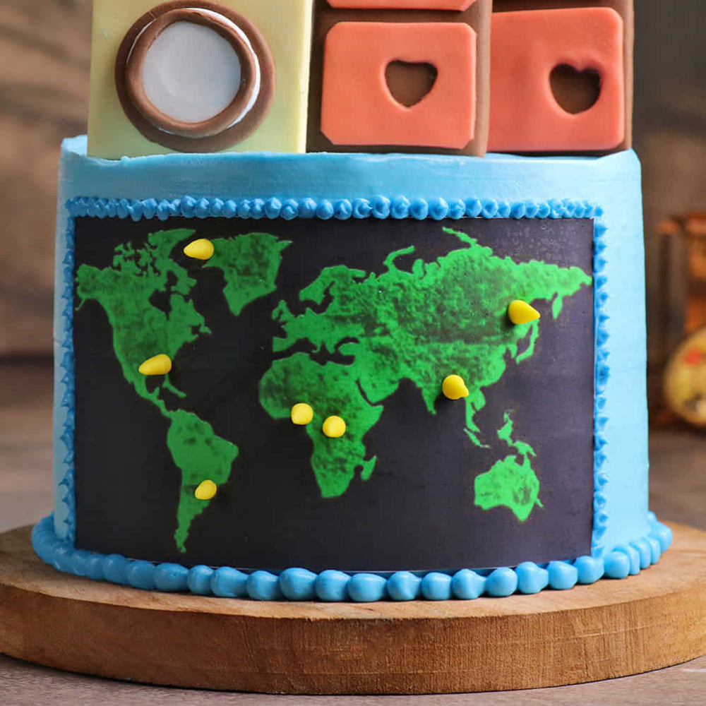 Travel theme designer cake with world map design, marking locations across continents, decorated in blue and green, perfect for travel lovers or global celebrations.