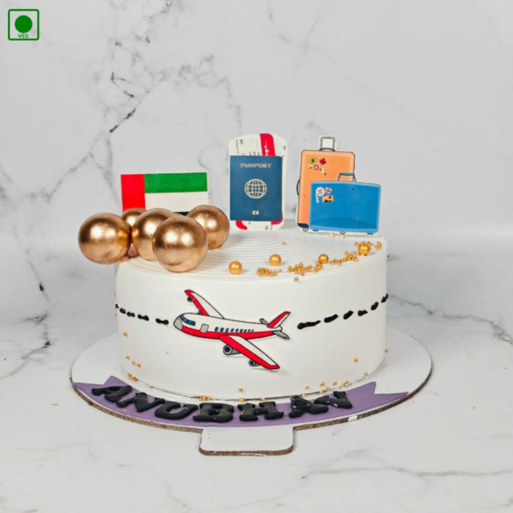 Travel theme designer cake with airplane, passport, suitcase toppers, UAE flag, and gold decorations, personalized with name Anubhav, perfect for farewell or travel celebration.