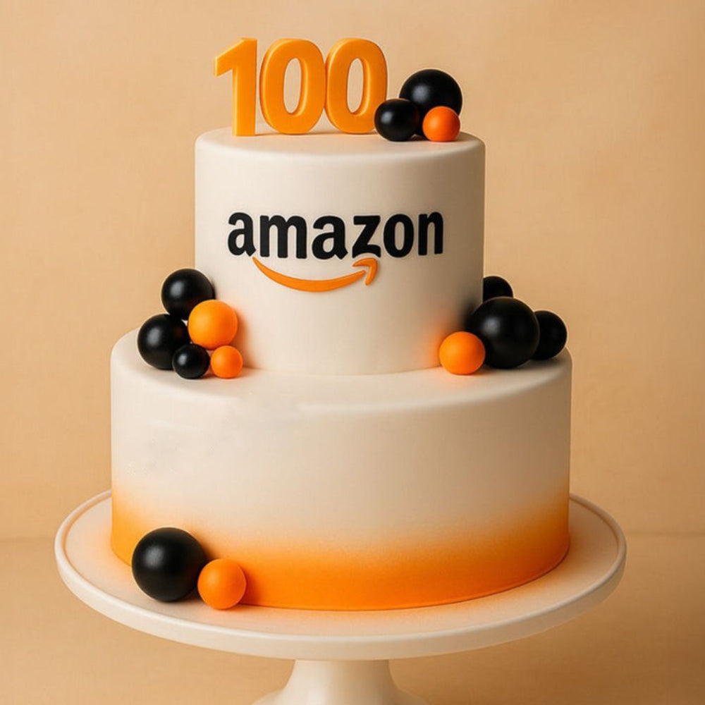 Two-tier Amazon milestone cake with "100" topper and orange and black sphere decorations.
