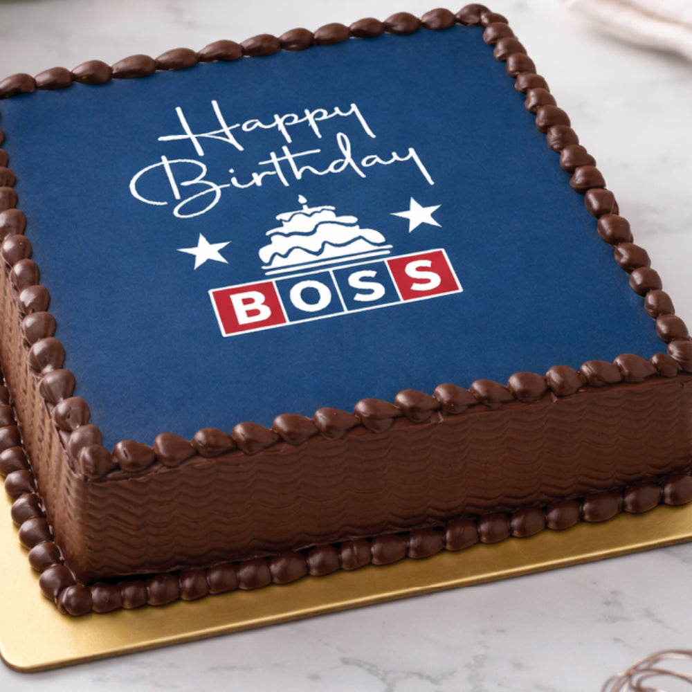 Square chocolate "Happy Birthday Boss" cake with navy blue edible print and decorative icing.