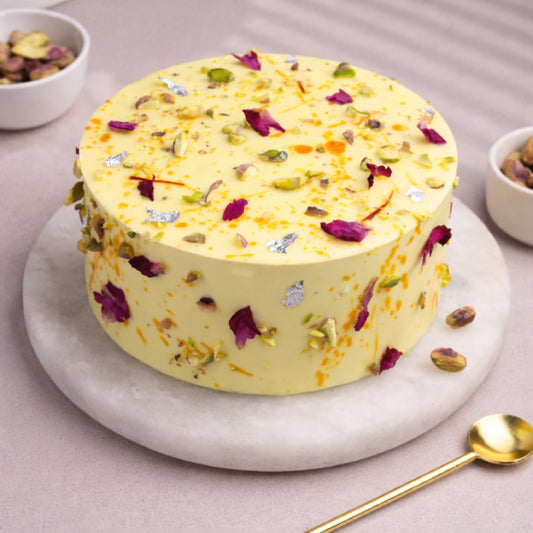 Elegant fusion designer cake with saffron, rose petals, and pistachio, perfect for celebrations.