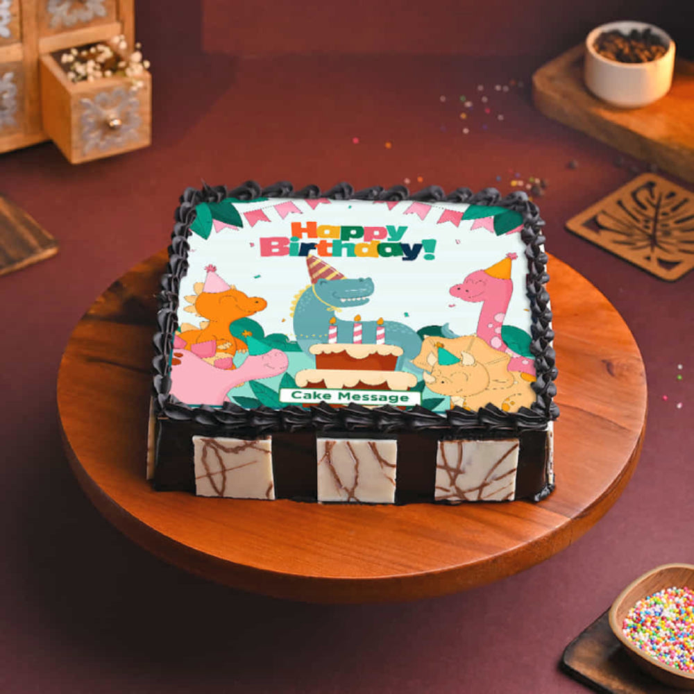 Birthday cake with cartoon animals and 'Happy Birthday!' text on a wooden table.