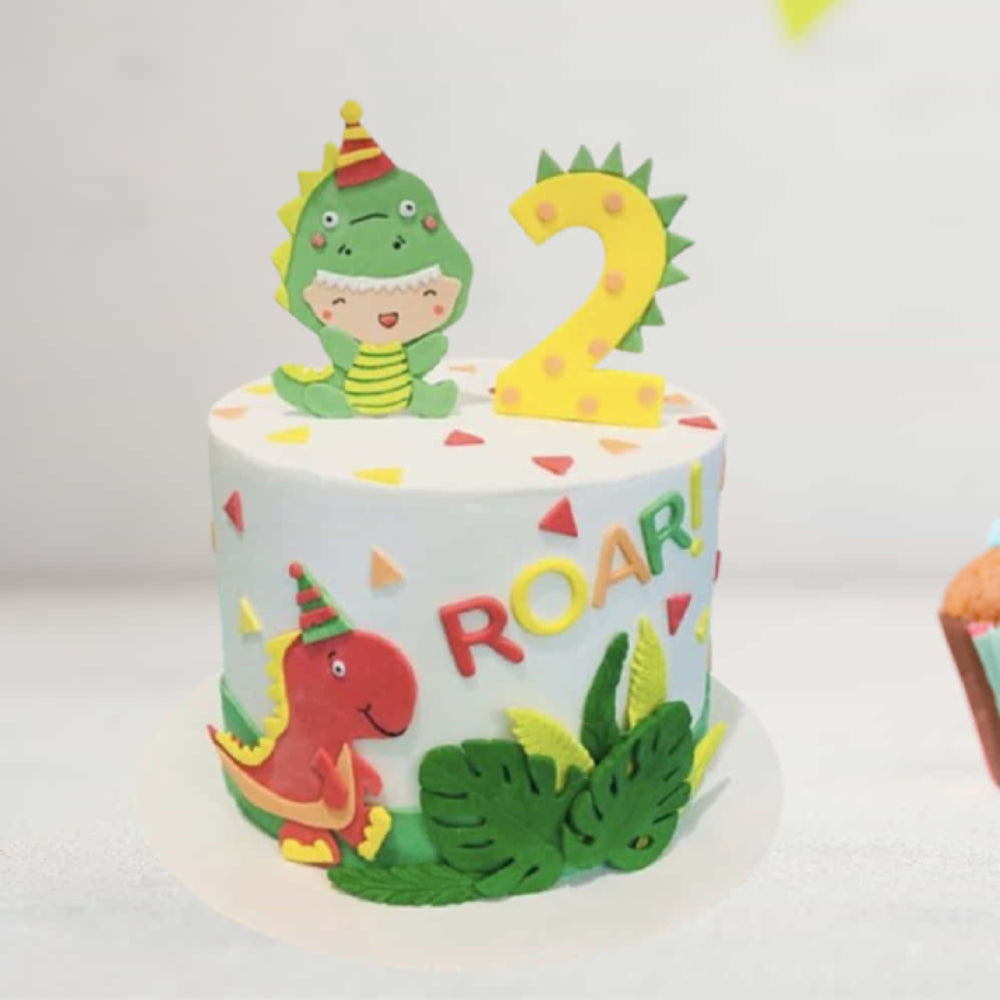 Children's birthday cake with dinosaur decorations and the number 2 on a white background