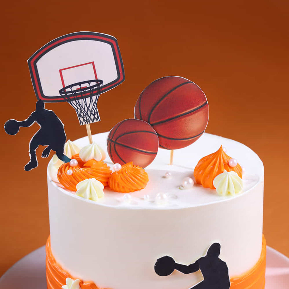 Basketball-themed cake with decorations on an orange background
