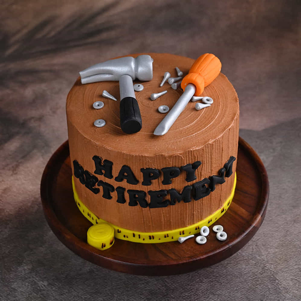 Handyman theme cake with hammer, screwdriver, and “Happy Retirement” message. top angle view