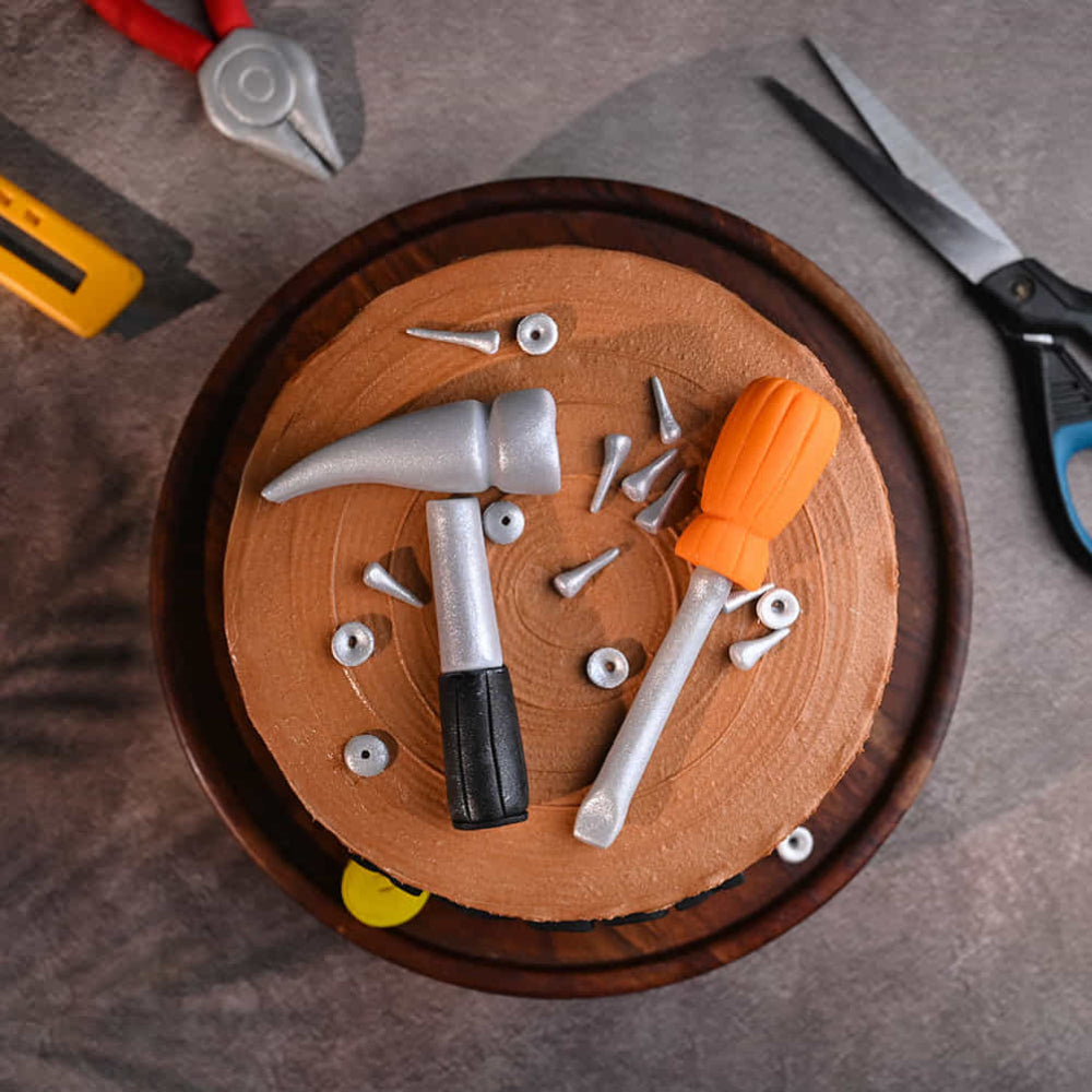 Handyman theme cake with hammer, screwdriver, and “Happy Retirement” message. top view