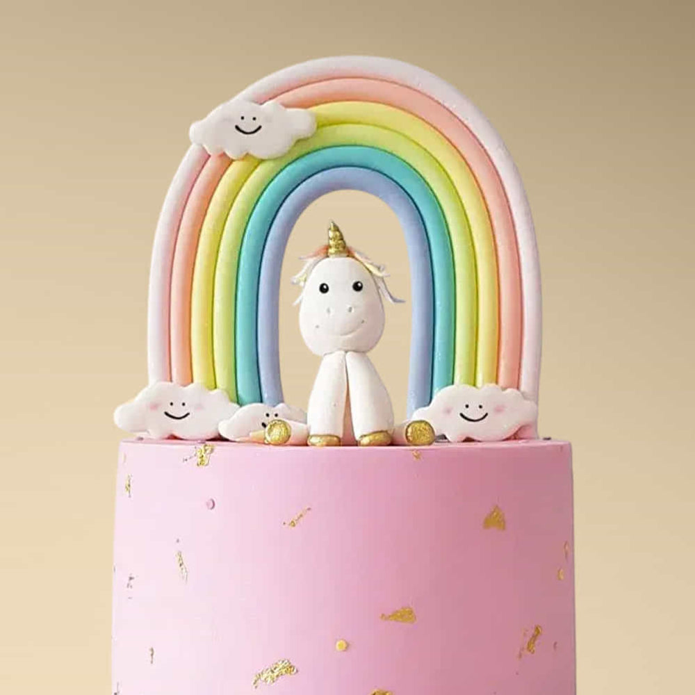 Decorative item with a unicorn, rainbow, and clouds on a pink base against a beige background