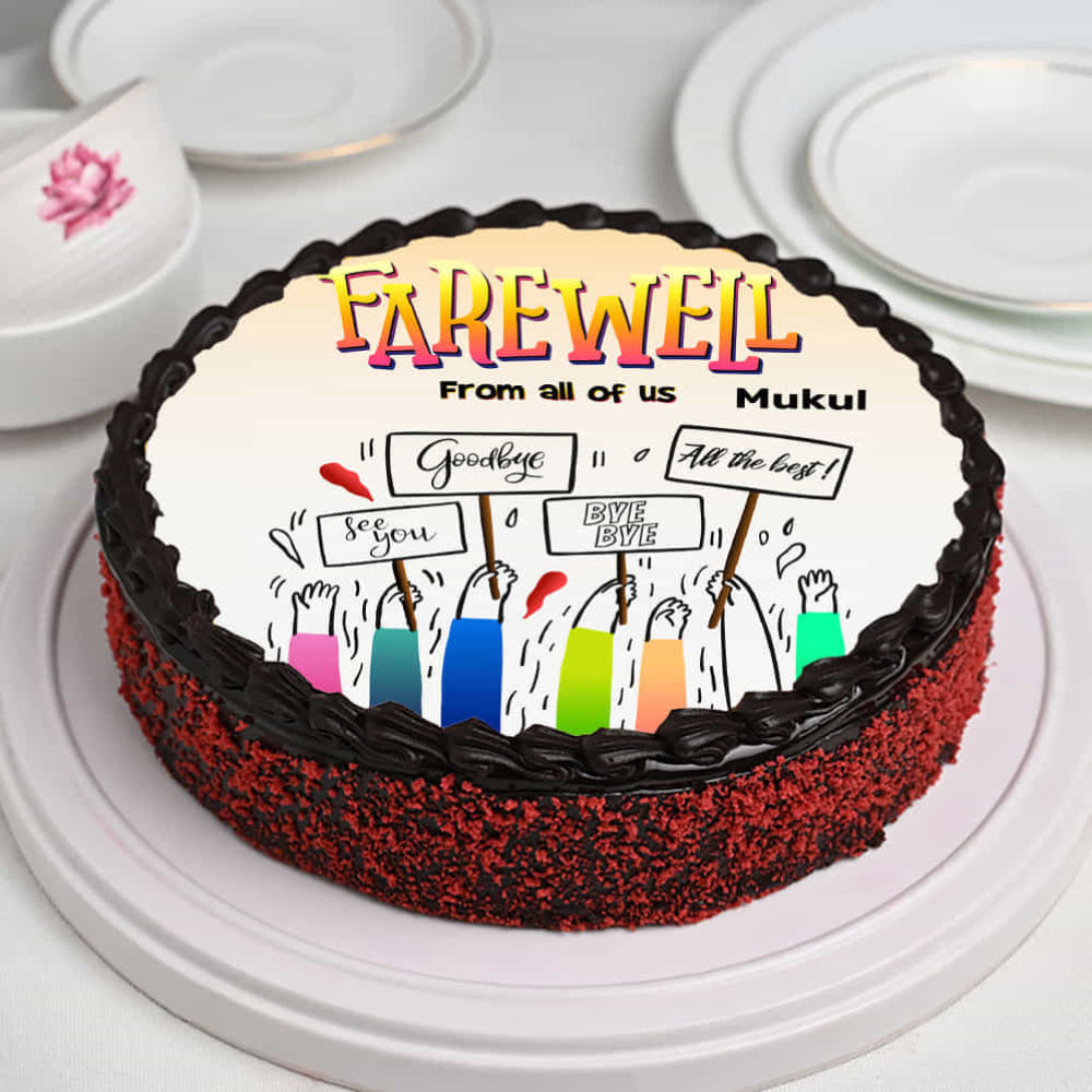 farewell cake with chocolate frosting and edible print of hands holding "Goodbye" signs.