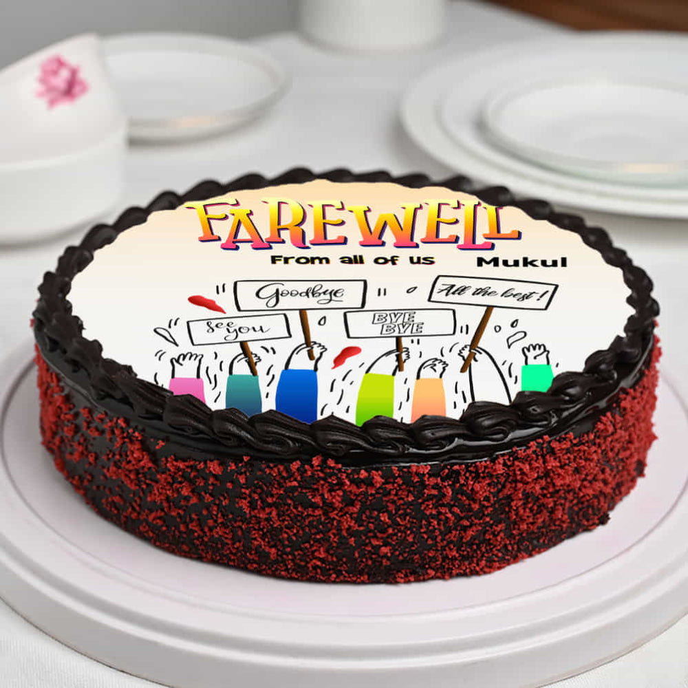 farewell cake with chocolate frosting and edible print of hands holding "Goodbye" signs.