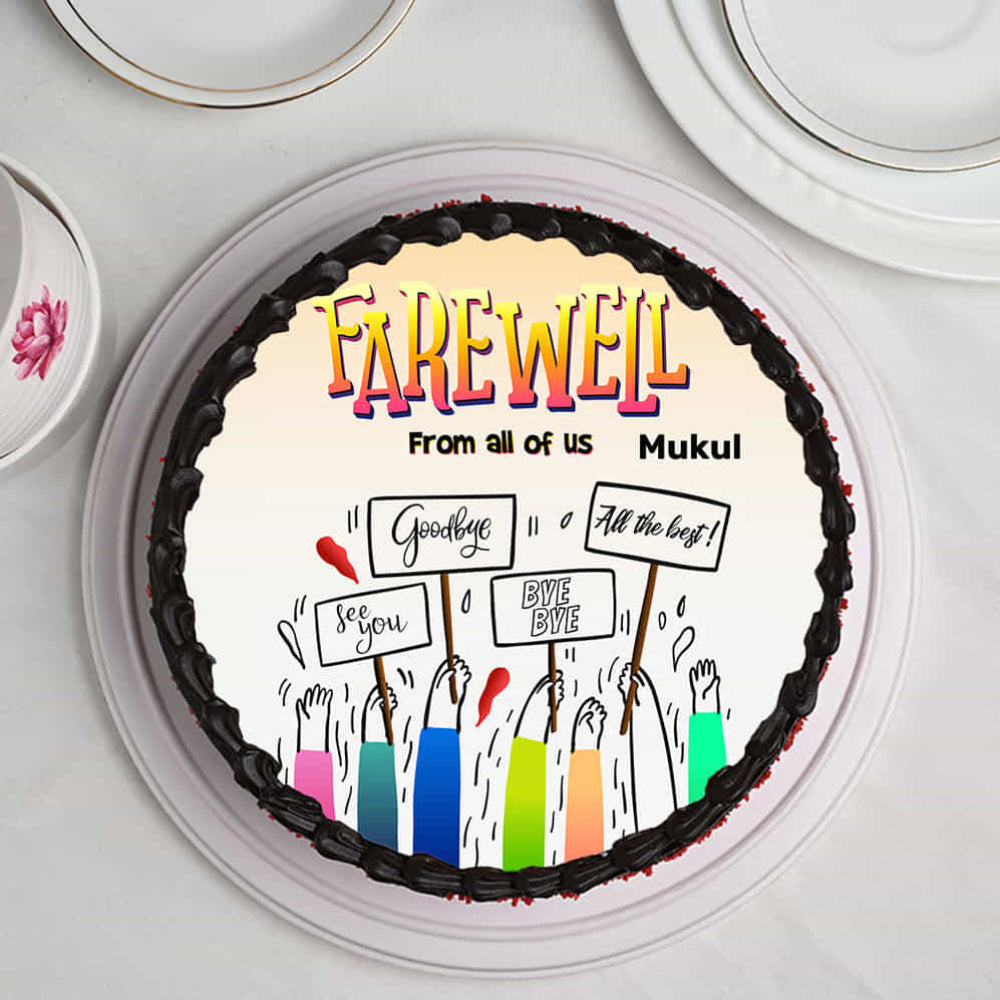 farewell cake with chocolate frosting and edible print of hands holding "Goodbye" signs. top view