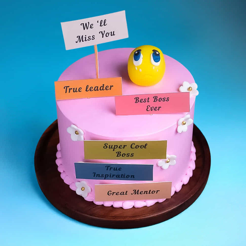 Pink farewell cake for a boss with a sad emoji and "We'll Miss You" messages.