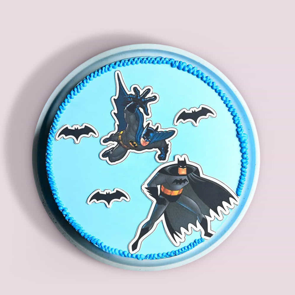Round blue cake with Batman illustrations on a light gray background